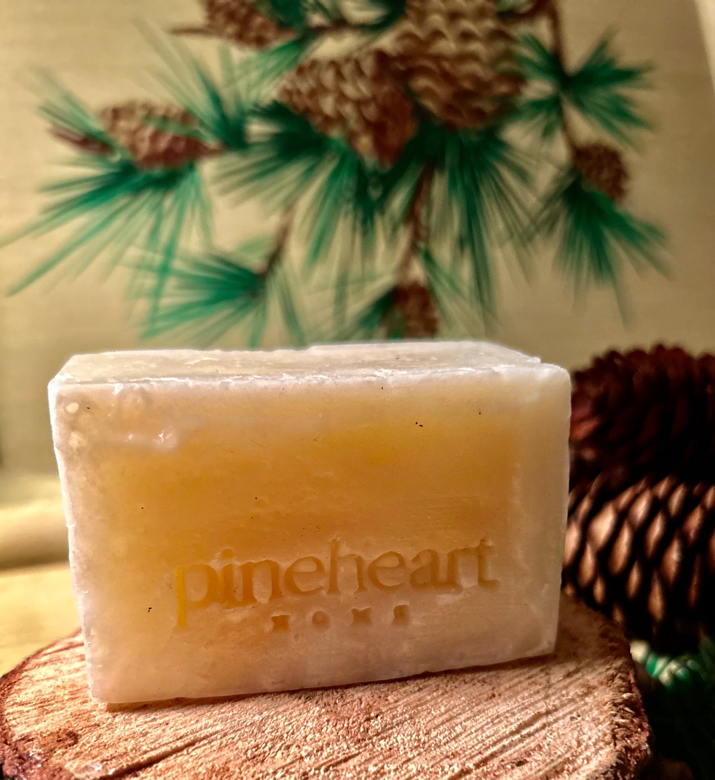 An alternate view of the unwrapped soap with pinecones in the background.